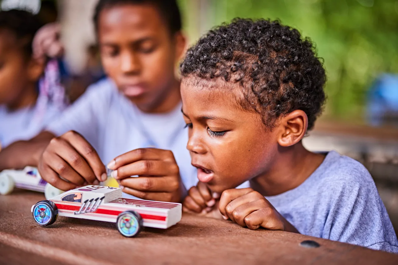 Cub Scouts examine a Pinewood Derby car