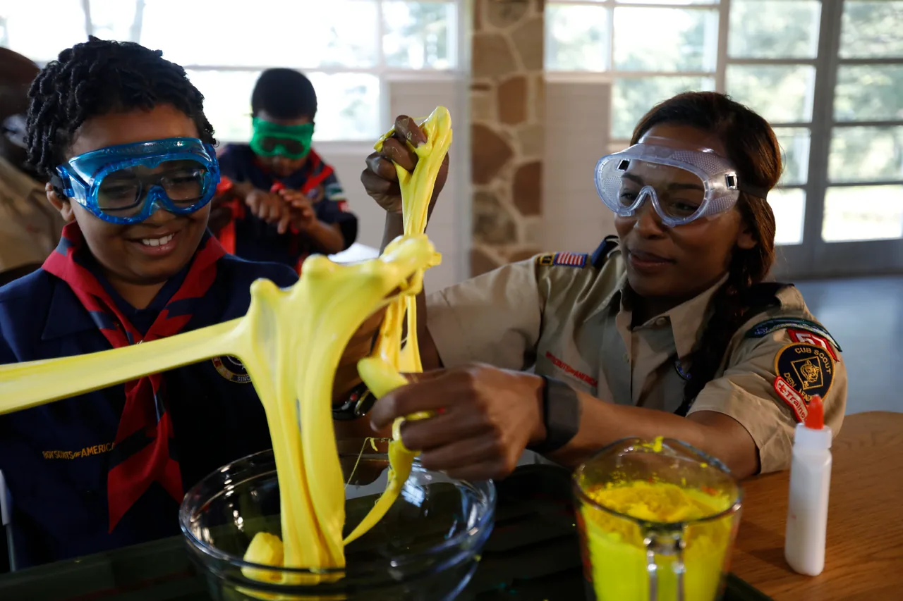 Cub Scouts and an adult leader explore a hands-on science activity