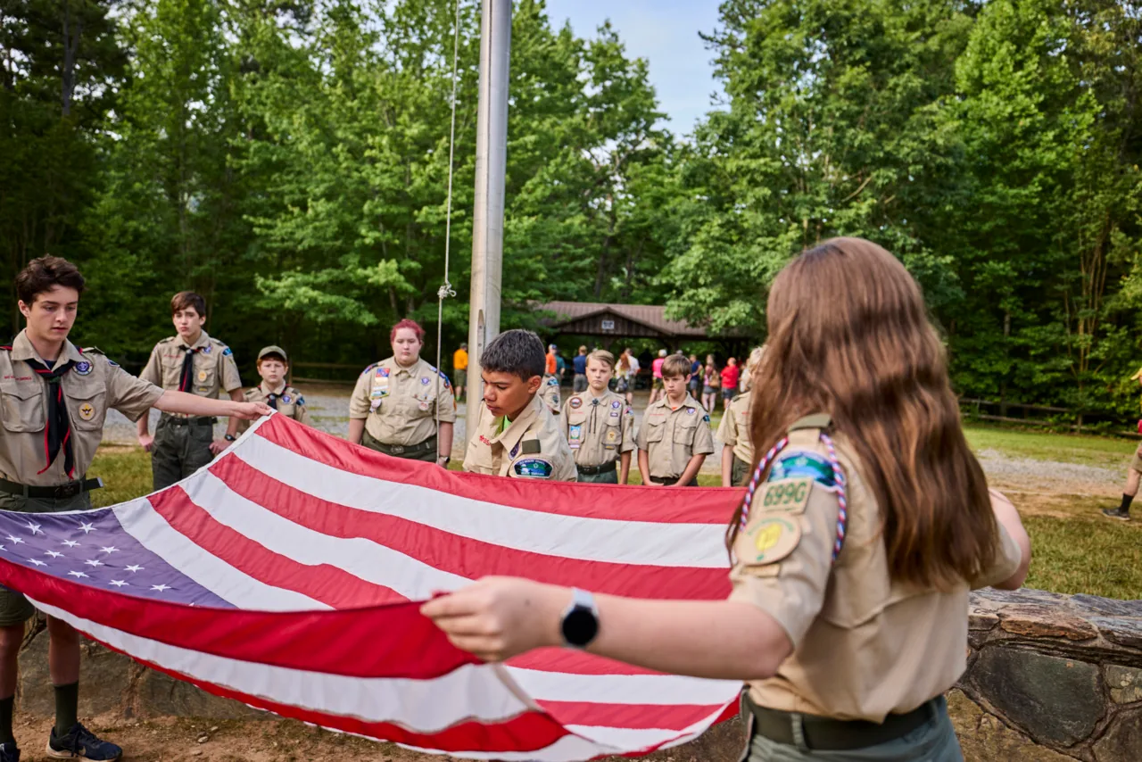 Scouts work together during an outdoor flag ceremony